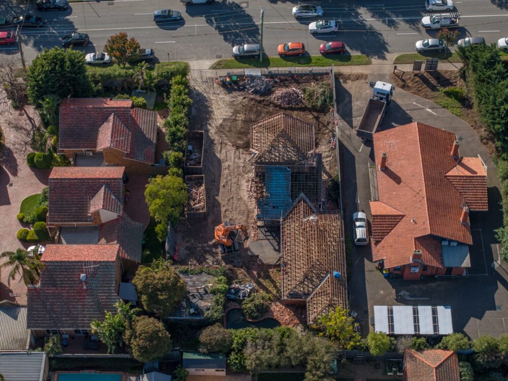 Aerial drone view of a partial demolition project between two existing residential properties