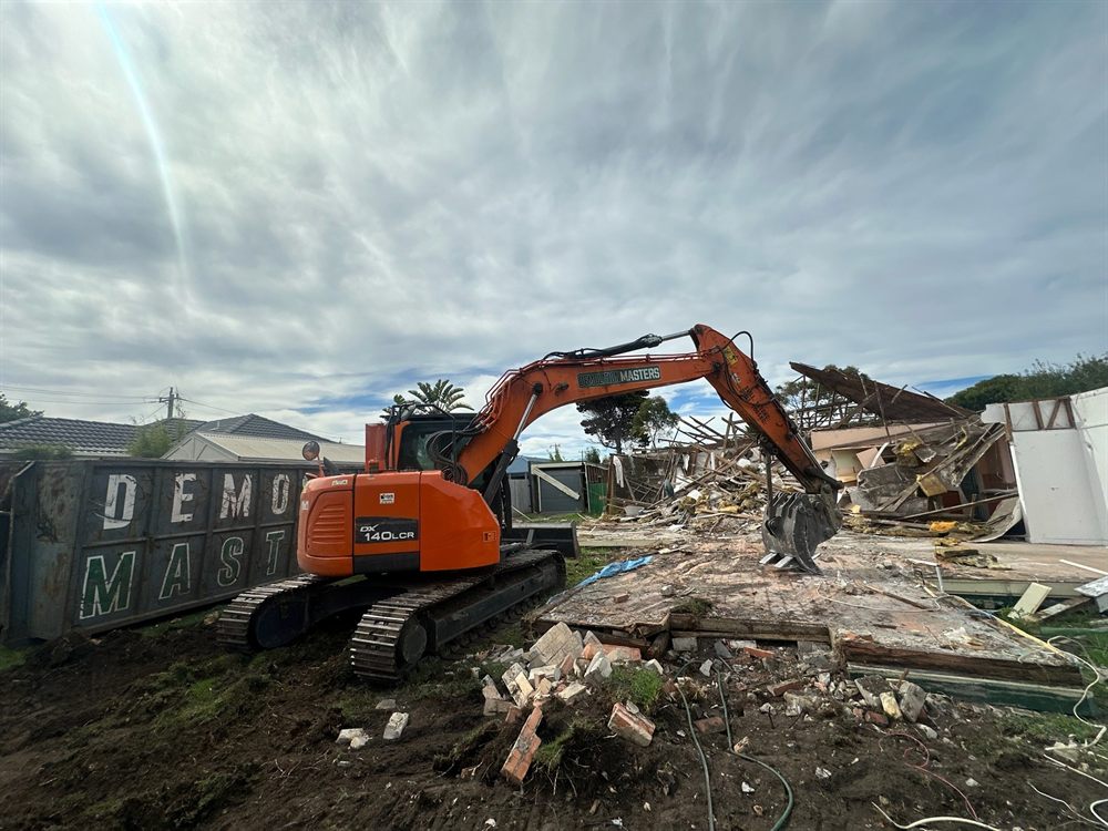 Branded Demolition Masters bin on a Melbourne demolition site with an excavator working alongside