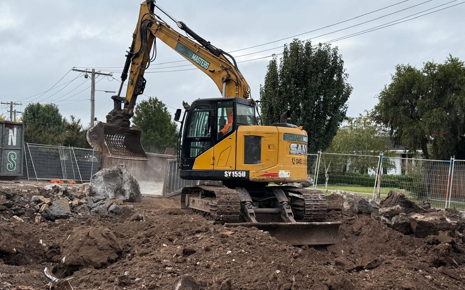 Yellow Demolition Masters excavator on a Melbourne earthworks site with cleared earth